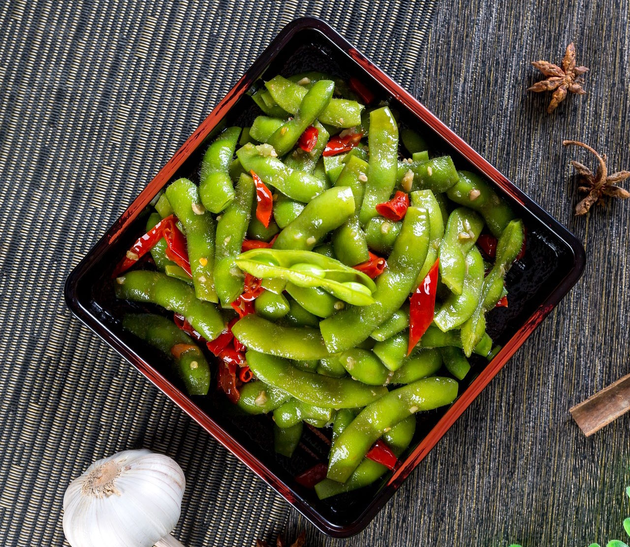 Vainas de soja tiernas cocidas y ligeramente saladas, servidas comúnmente como aperitivo en la cocina japonesa. En España, el edamame se está haciendo popular en bares y restaurantes como opción saludable y deliciosa, ideal para picar antes de la comida principal. Su preparación sencilla y su sabor suave, pero satisfactorio, lo convierten en una excelente introducción a los sabores japoneses para paladares no acostumbrados a la cocina oriental.