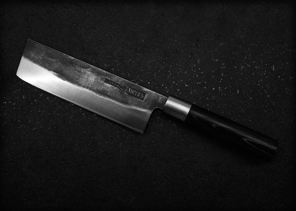 En el corazón de la cocina japonesa están sus cuchillos, cada uno diseñado para tareas específicas. El Santoku, por ejemplo, es conocido por su versatilidad, ideal para cortar, picar y rebanar tanto carne como verduras. Por otro lado, el Yanagiba se reserva para el sashimi, permitiendo cortes precisos y finos que resaltan la frescura del pescado. Estos cuchillos no son simplemente herramientas, sino extensiones del chef, forjados y afilados con técnicas que han sido perfeccionadas a lo largo de siglos.