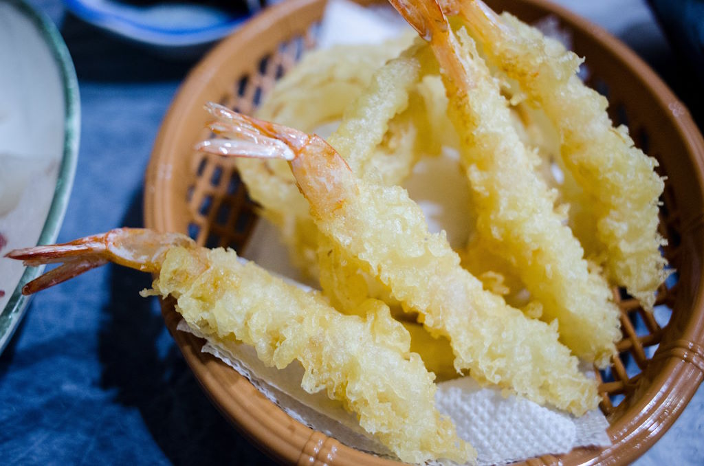La tempura, otro plato icónico de Japón, ha encontrado fácilmente su lugar en las mesas españolas. Consiste en mariscos y vegetales bañados en una ligera y aireada masa de harina y luego fritos hasta alcanzar un color dorado perfecto. La clave de una buena tempura radica en su textura crujiente, sin ser grasosa, y en la habilidad para resaltar los sabores naturales de sus ingredientes. A menudo servida con una salsa tensuyu para mojar, la tempura ofrece una experiencia culinaria que equilibra el sabor delicado con la satisfacción de un bocado crujiente.