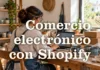 Comercio electrónico con Shopify Profesional de un pequeño taller junto a un portátil, tazas y cajas de envío.