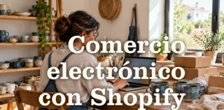 Comercio electrónico con Shopify Profesional de un pequeño taller junto a un portátil, tazas y cajas de envío.