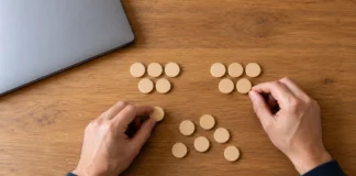 Manos adultas agrupando fichas de madera para practicar repartos y cálculos.