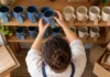Organiza variantes y existencias sin vender de más Persona contando tazas de distintos colores en estanterías de un taller.