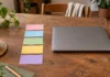 Tarjetas de colores ordenadas en una fila junto a un portátil cerrado.