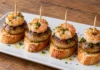 Pintxo de champiñón y gamba Champiñones dorados y gambas peladas sobre pan, sujetos con palillos y con perejil.