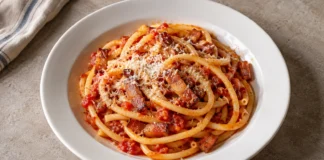 Bucatini a la amatriciana Bucatini con tomate, tiras doradas de guanciale y una capa ligera de pecorino rallado.