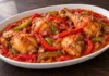 Pollo en salsa de tomate con tiras de pimiento rojo y verde y dados de jamón.