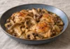 Contramuslos de pollo con champiñones y setas de ostra en un plato azul gris.