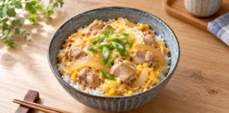 Donburi: los cuencos de arroz de la cocina japonesa Oyakodon con pollo, huevo y cebolla sobre arroz en un cuenco de cerámica